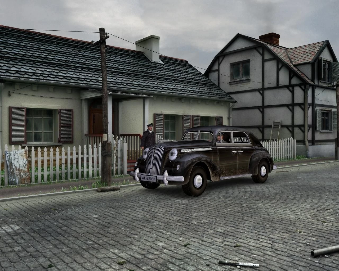 Calle adoquinada con casas de tejado de pizarra y una valla blanca; ante una de ellas, un coche negro de los años cuarenta y un hombre de uniforme