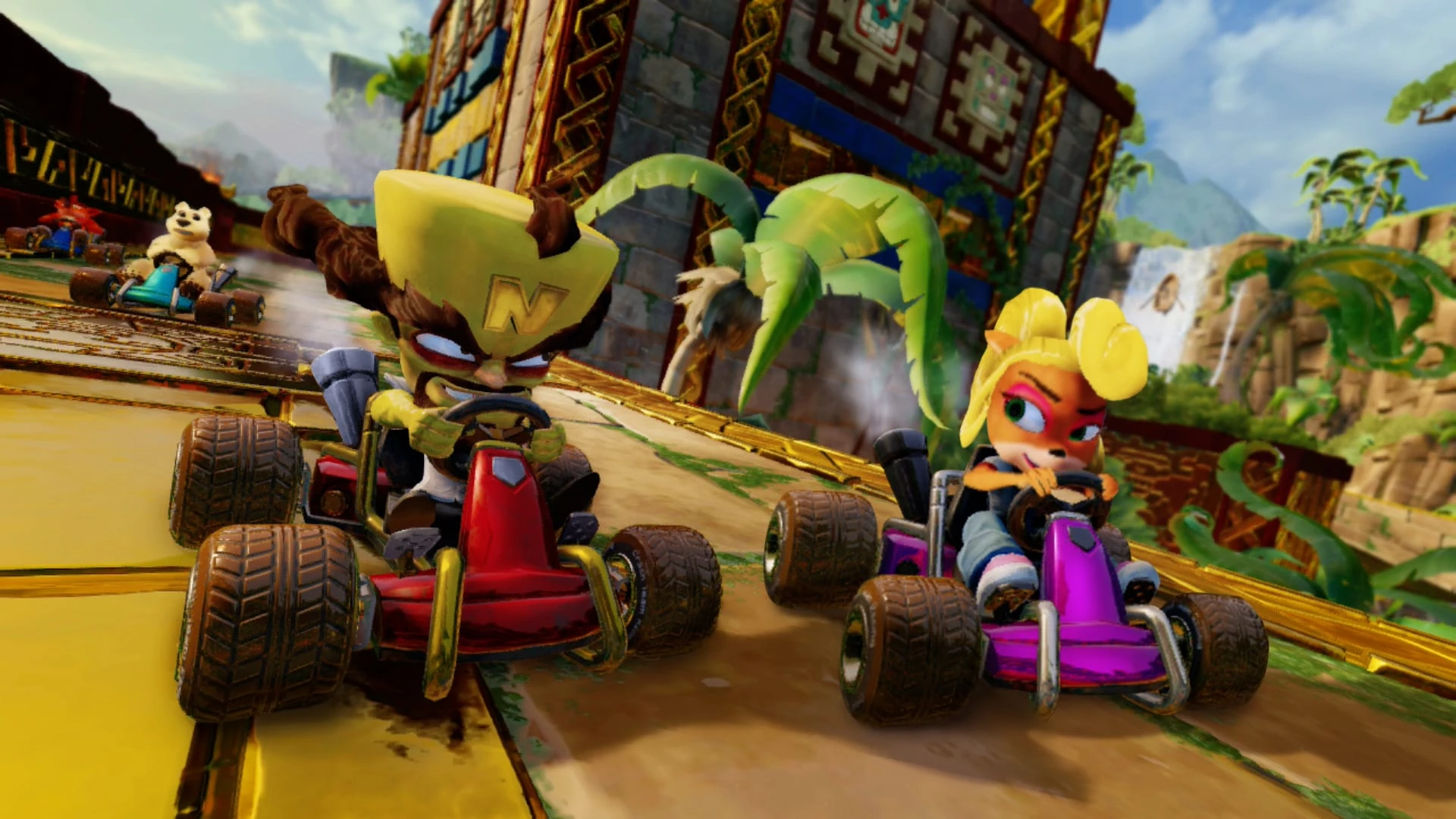 Cortex, en un kart rojo, y Coco, en uno morado, corren juntos ante un templo de piedra en la selva