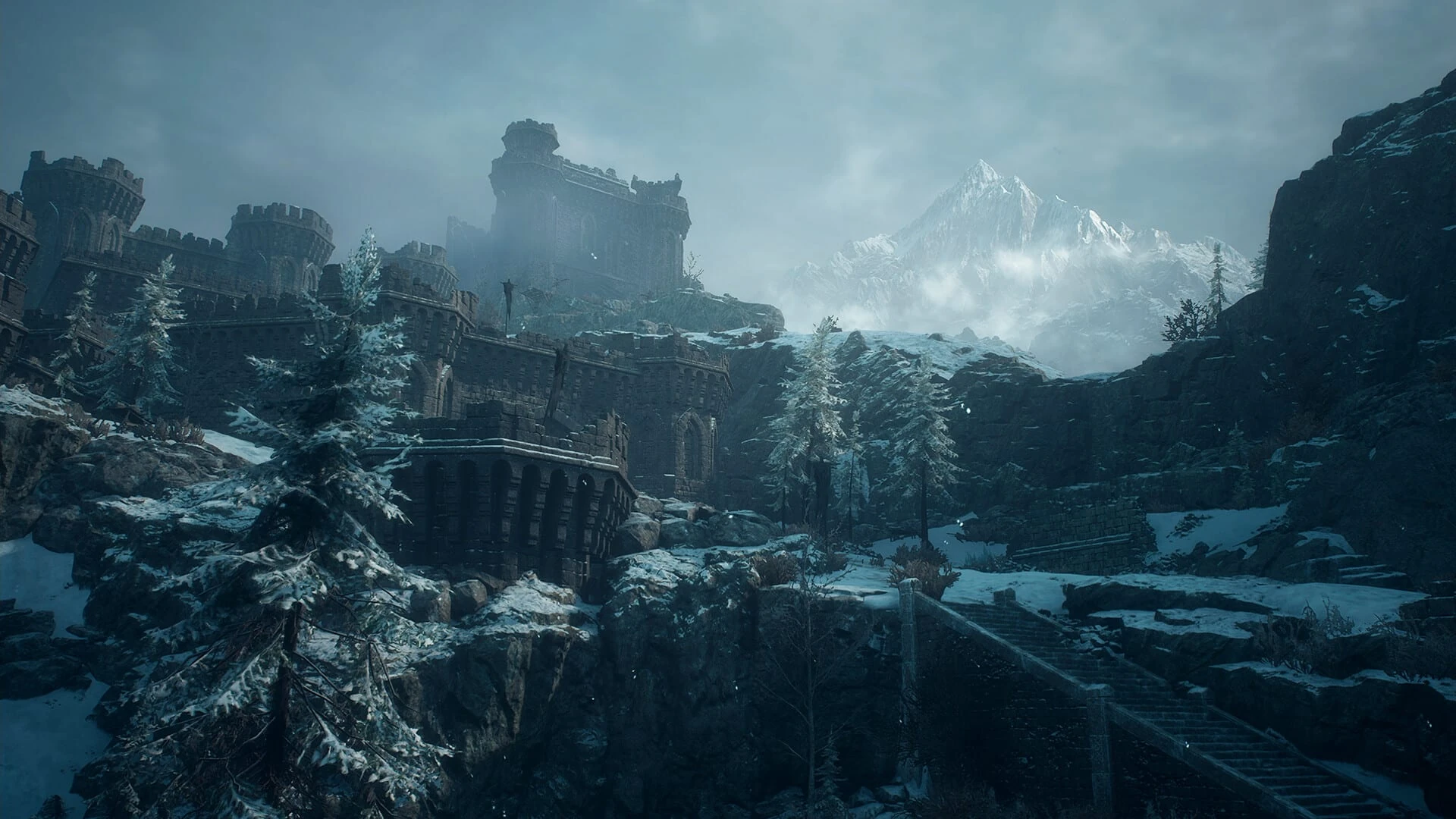 Las ruinas de una fortaleza de piedra en una ladera nevada, con abetos cubiertos de nieve y una cordillera entre la niebla al fondo