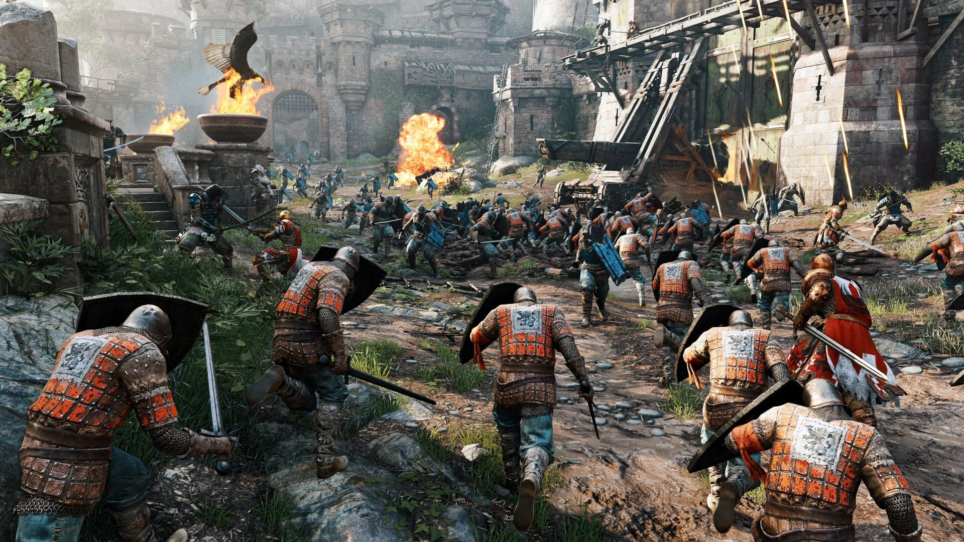 Decenas de soldados con sobrevesta naranja corren cuesta arriba hacia la puerta de un castillo que un ariete está reventando, entre braseros encendidos y flecha