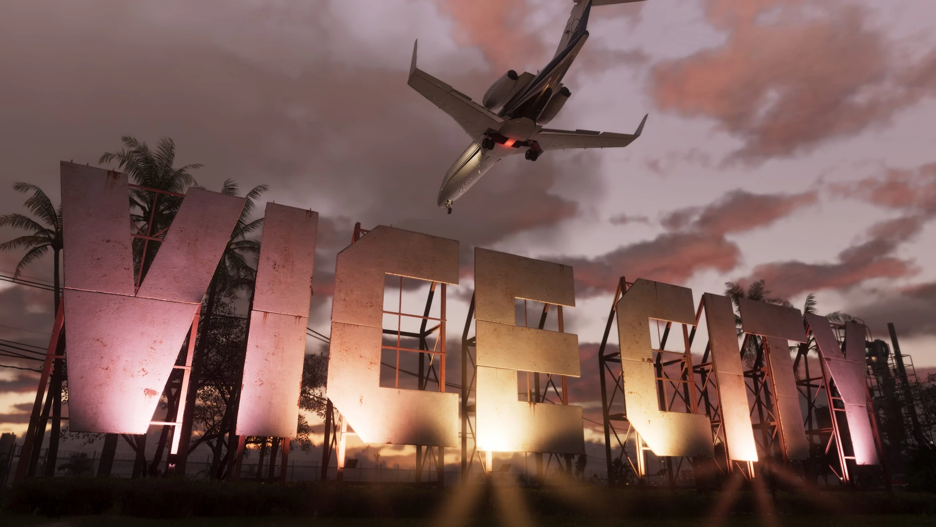 Las letras gigantes del rótulo VICE CITY al atardecer, entre palmeras, con un avión privado pasando muy bajo por encima
