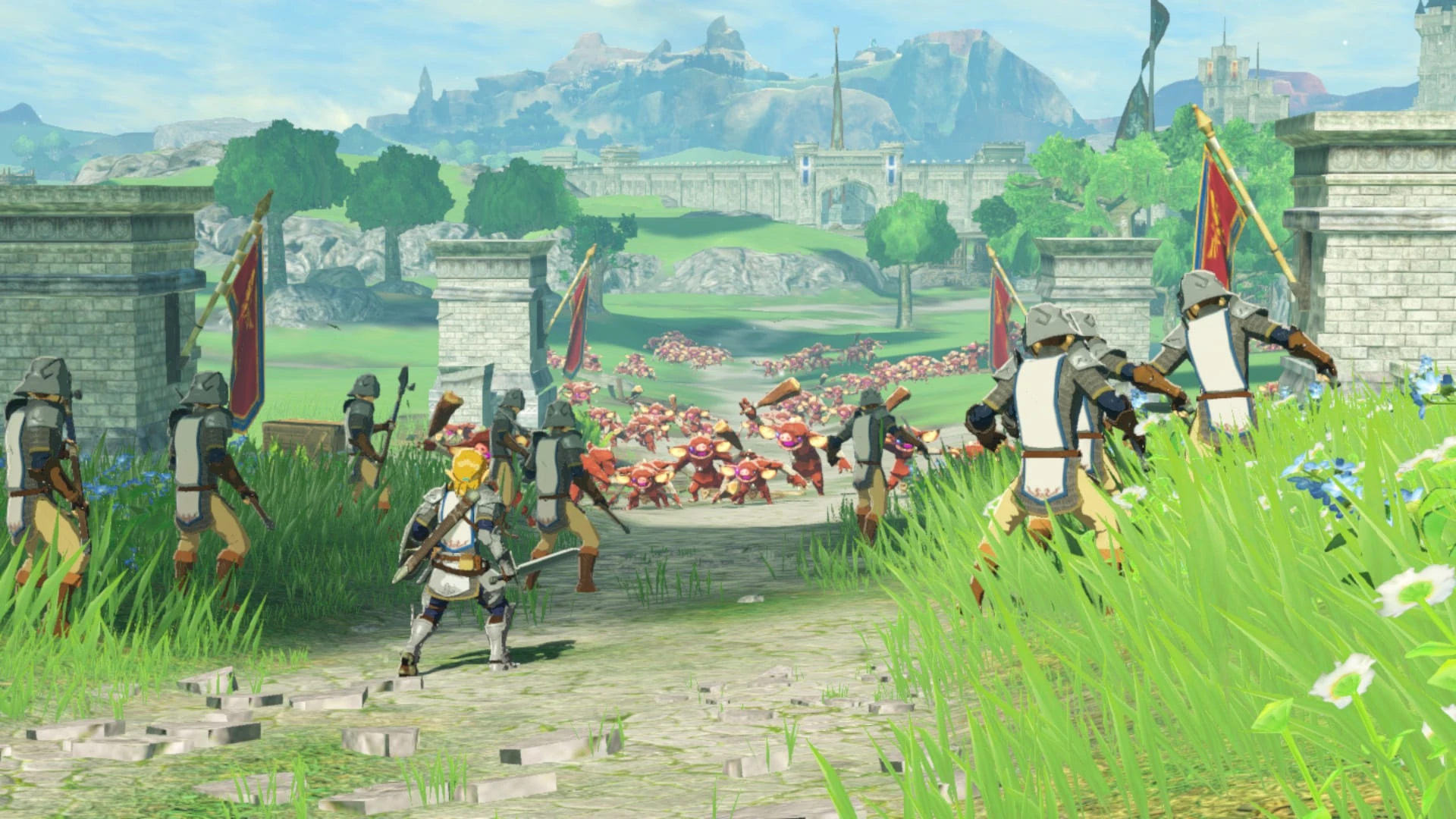 Link avanza por un camino de piedra entre soldados de Hyrule con estandartes rojos hacia una horda de bokoblins, con el castillo al fondo