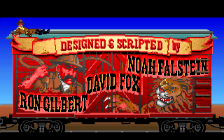 Indy tumbado en el techo de un vagón rojo ilustrado con un león; en el costado se lee Designed and scripted by Ron Gilbert, David Fox y Noah Falstein