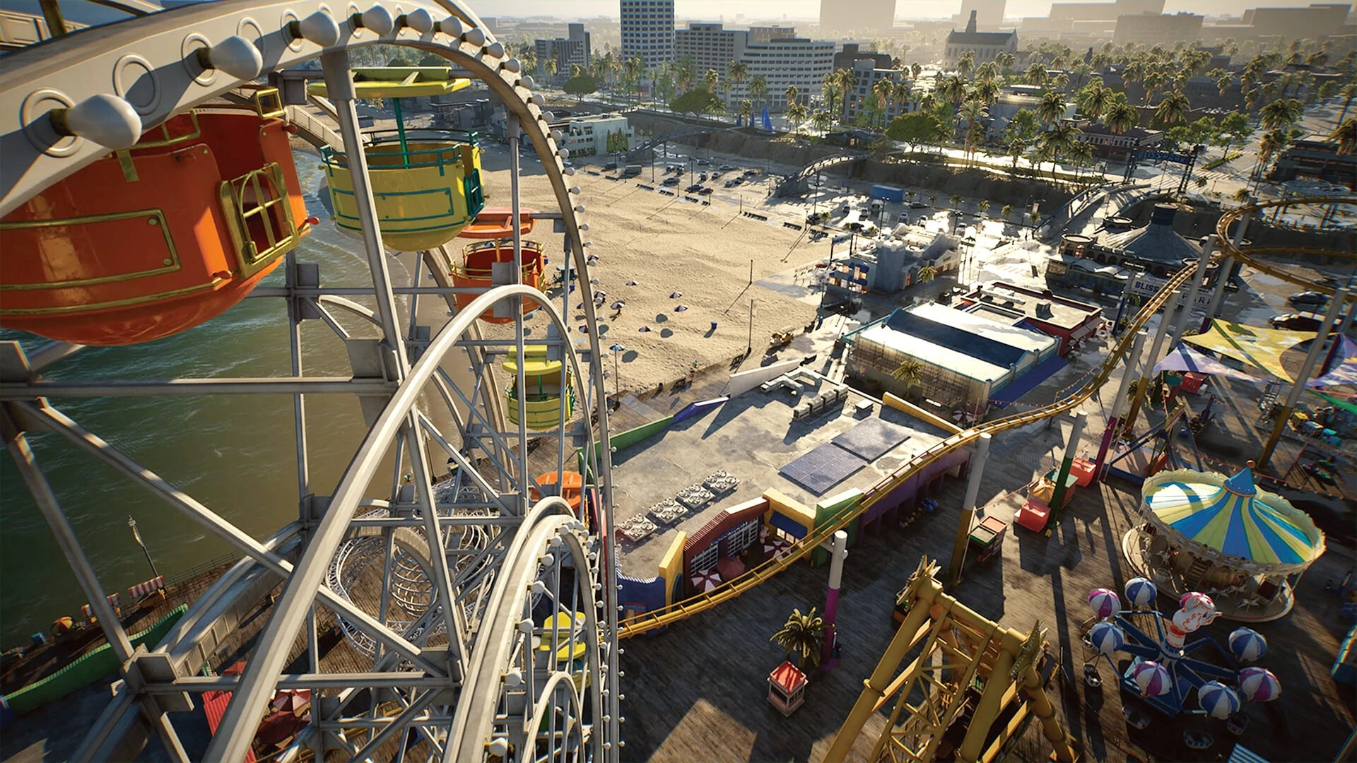 Una noria y una montaña rusa en un muelle de feria, con la playa, un paseo y los edificios de la ciudad detrás