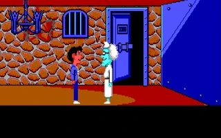 El doctor Fred, con bata y pelo blancos, junto a uno de los chavales delante de una puerta acorazada en un sótano de piedra