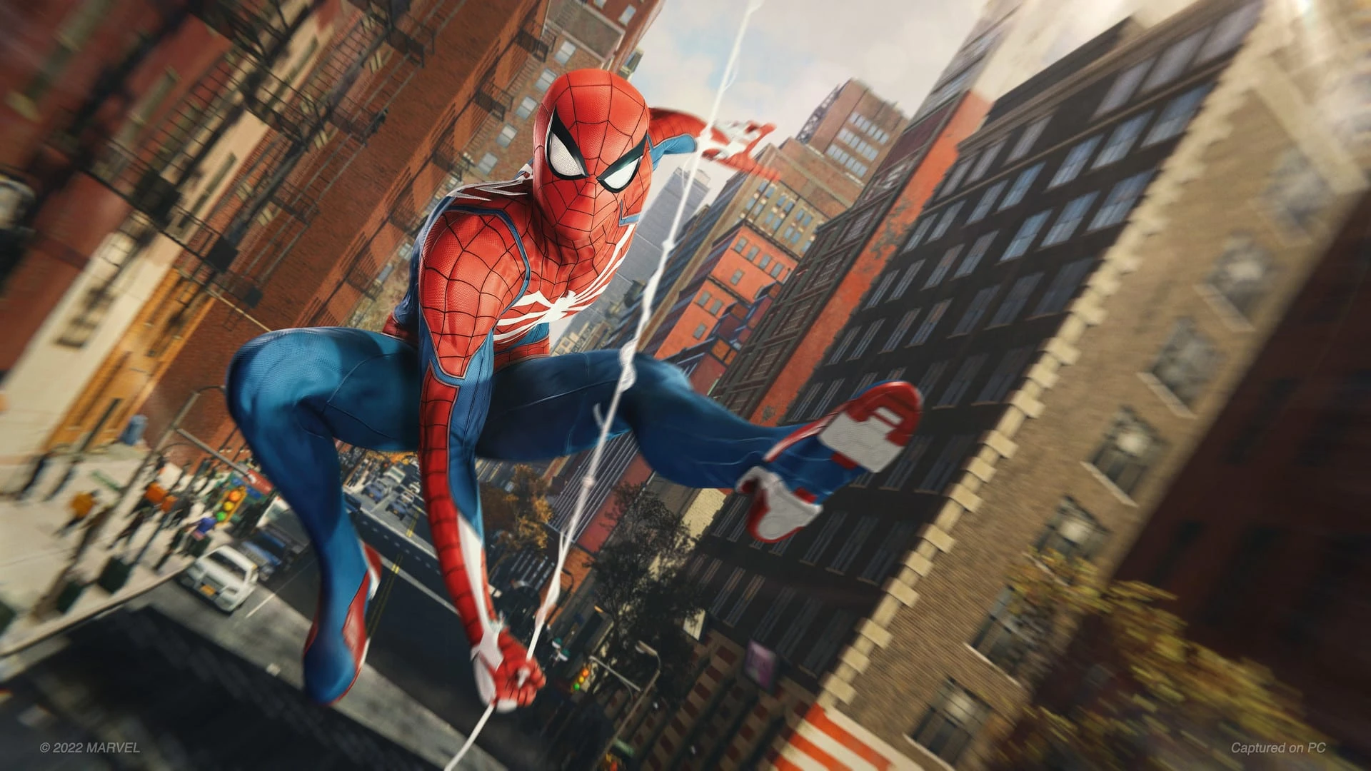 Spider-Man se balancea colgado de la telaraña entre edificios de ladrillo de Manhattan, con la calle muy abajo