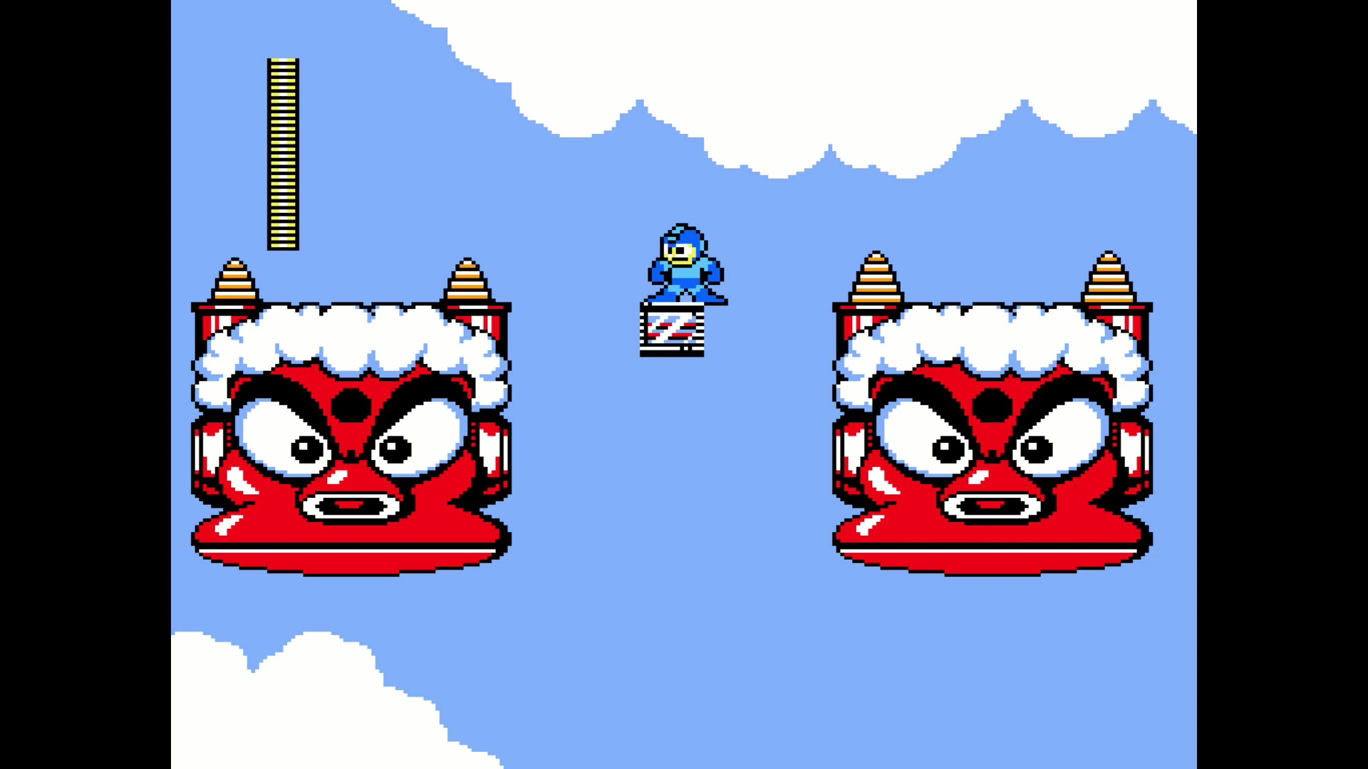 Mega Man sobre una pequeña plataforma flotante, entre dos enormes cabezas rojas con cuernos y cejas fruncidas, en un cielo azul con nubes