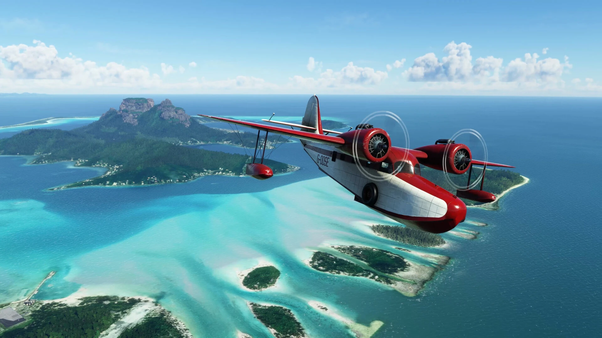 Un hidroavión rojo y blanco de dos motores sobrevuela una laguna turquesa rodeada de islas y arrecifes