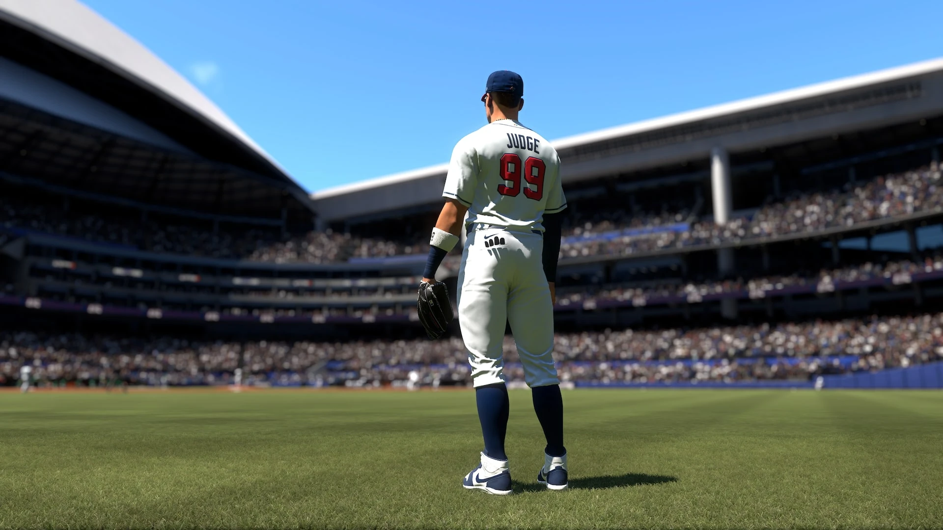Aaron Judge, de espaldas con el número 99, en el jardín de un estadio lleno bajo el cielo azul