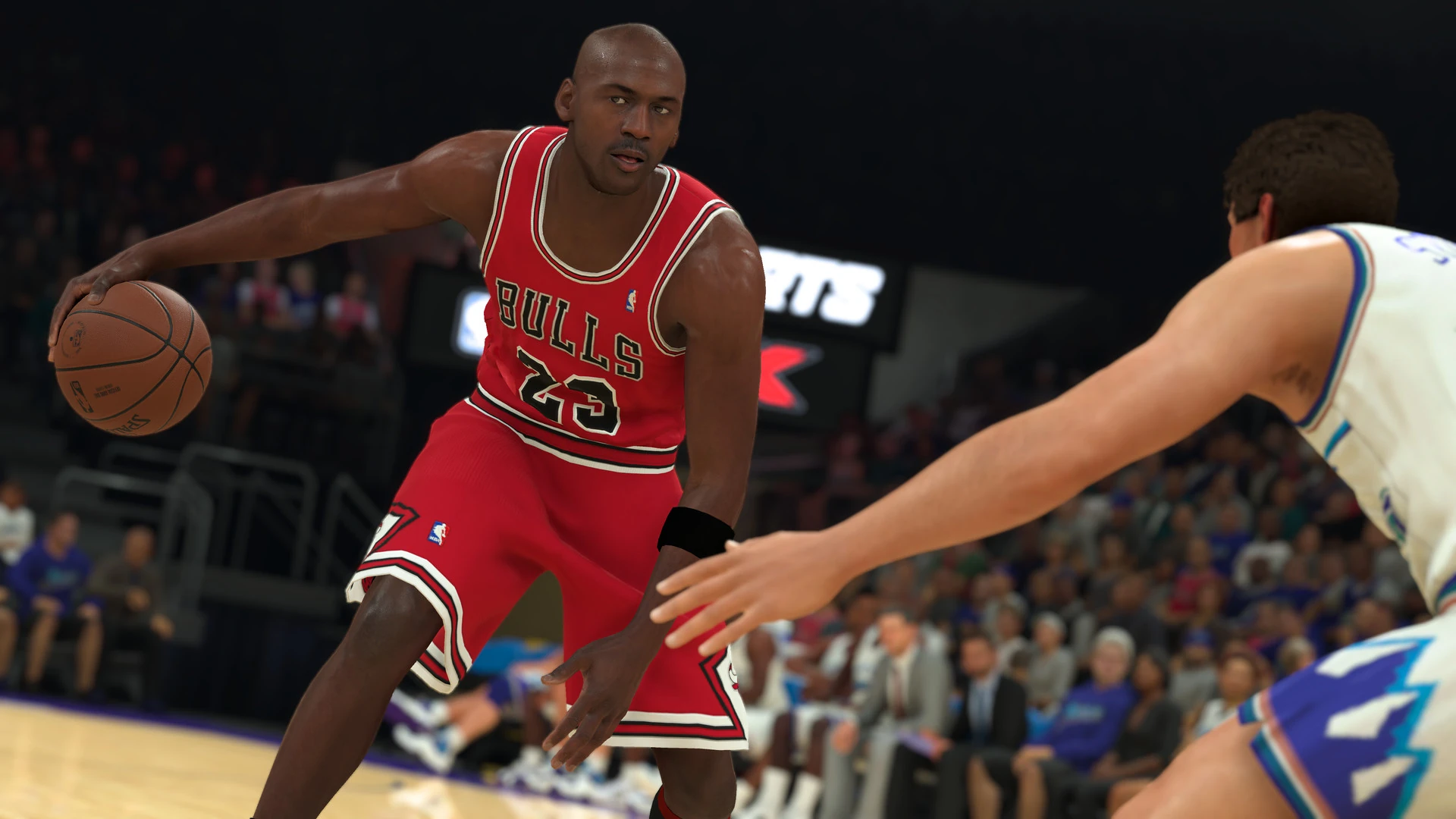 Michael Jordan, con la camiseta roja número 23 de los Bulls, bota el balón ante un defensor en un pabellón lleno