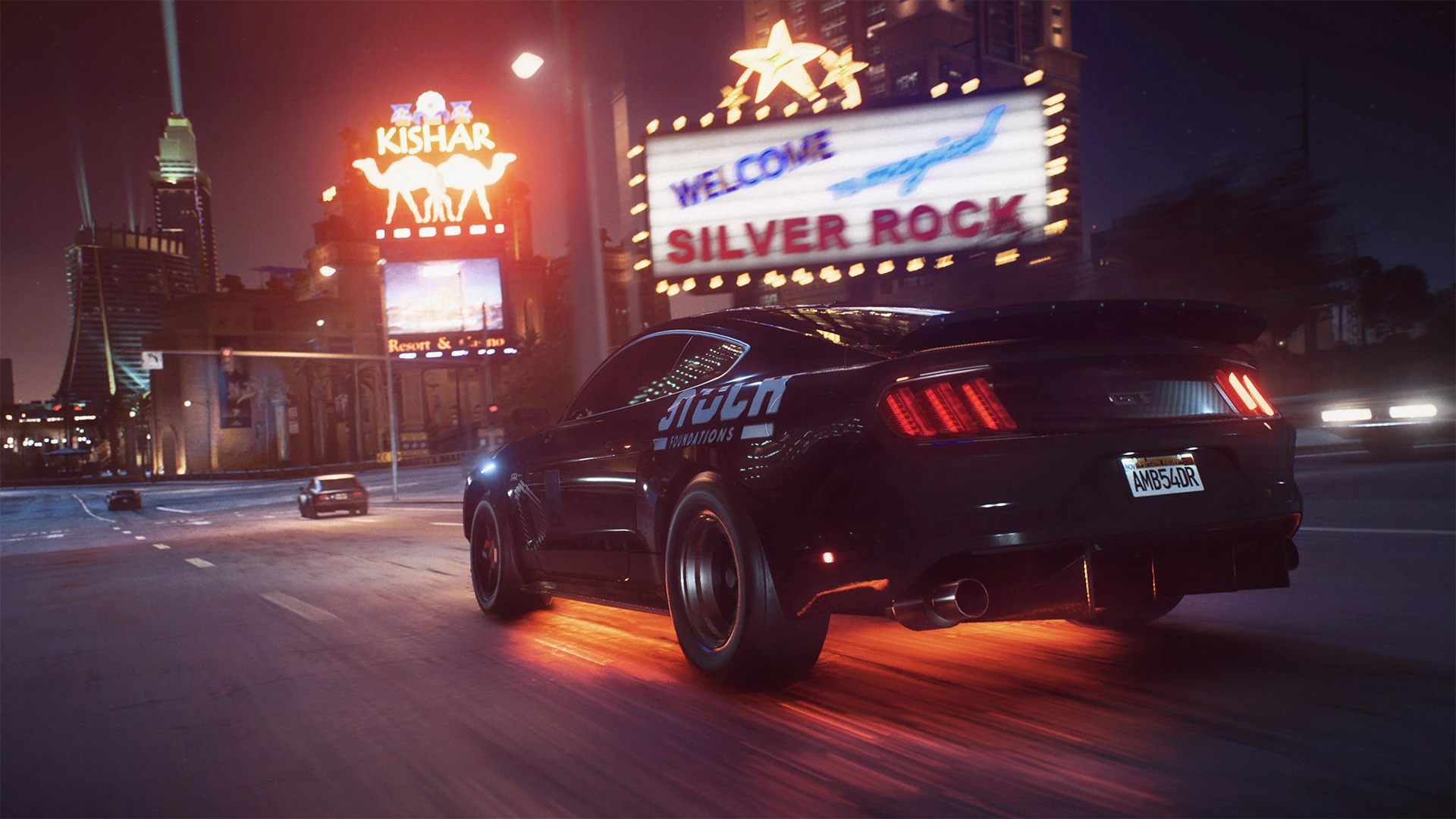 Un Ford Mustang negro con luces de bajos naranjas pasa de noche junto al gran cartel luminoso de Silver Rock