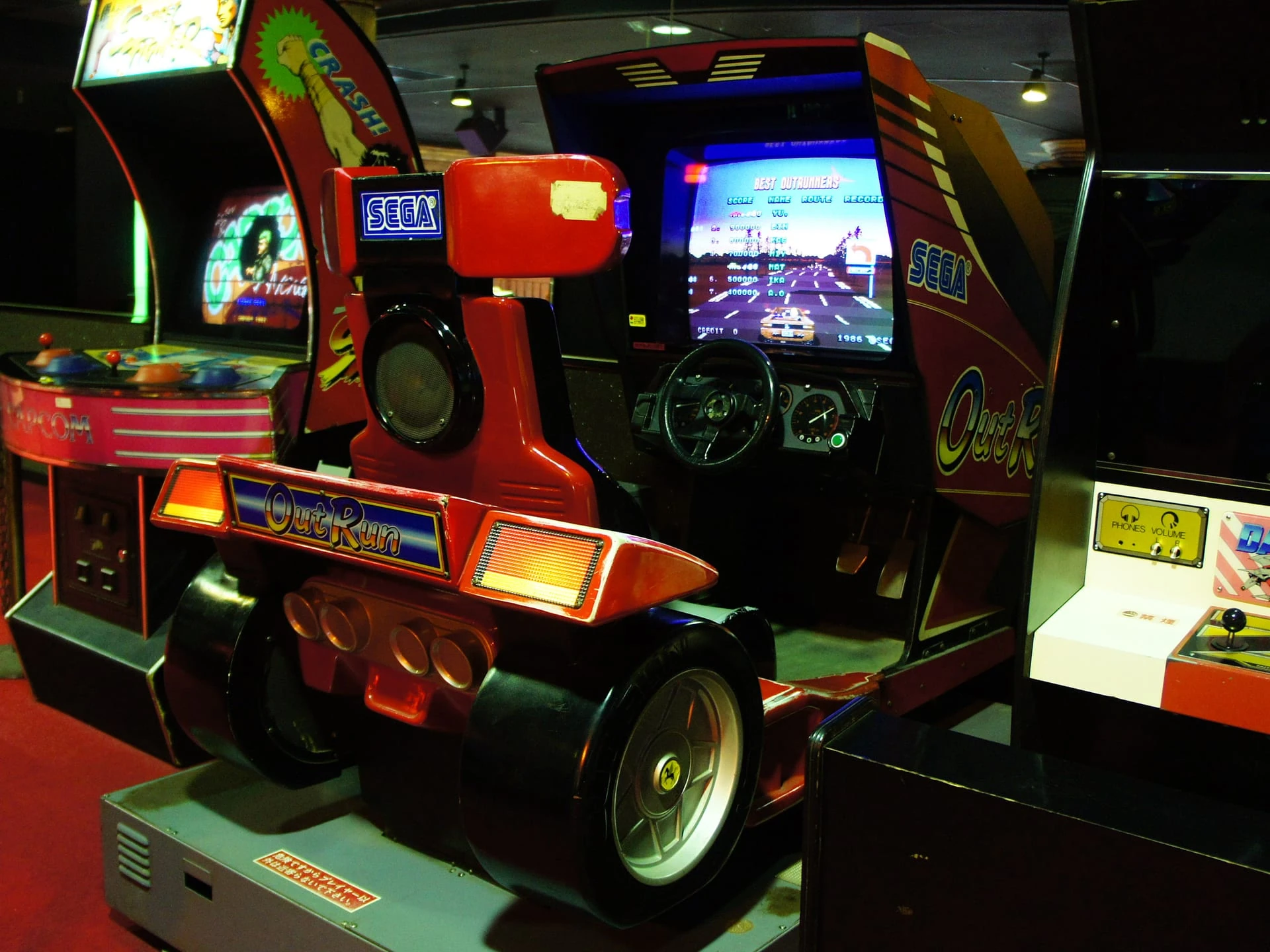 Mueble de cabina de Out Run en un salón recreativo: la parte trasera imita un deportivo rojo y la pantalla muestra la tabla de récords