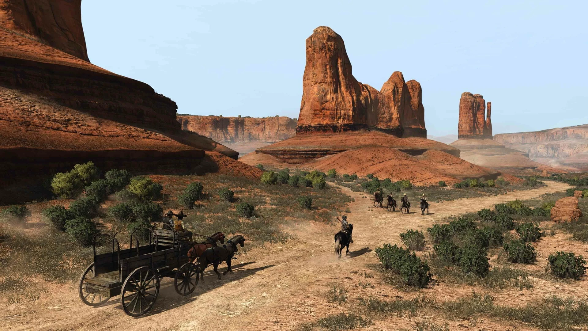 Una carreta tirada por caballos y un jinete avanzan por un camino de tierra en un desierto rojizo, con grandes formaciones de roca al fondo bajo un cielo azul