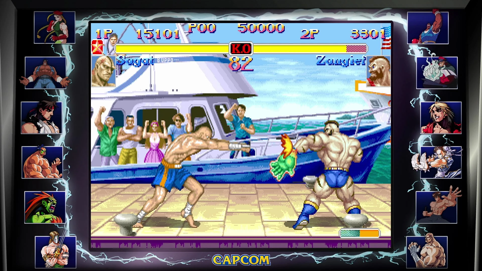 Sagat golpea a Zangief en un muelle con un yate lleno de público, dentro de un marco con retratos de luchadores a los lados