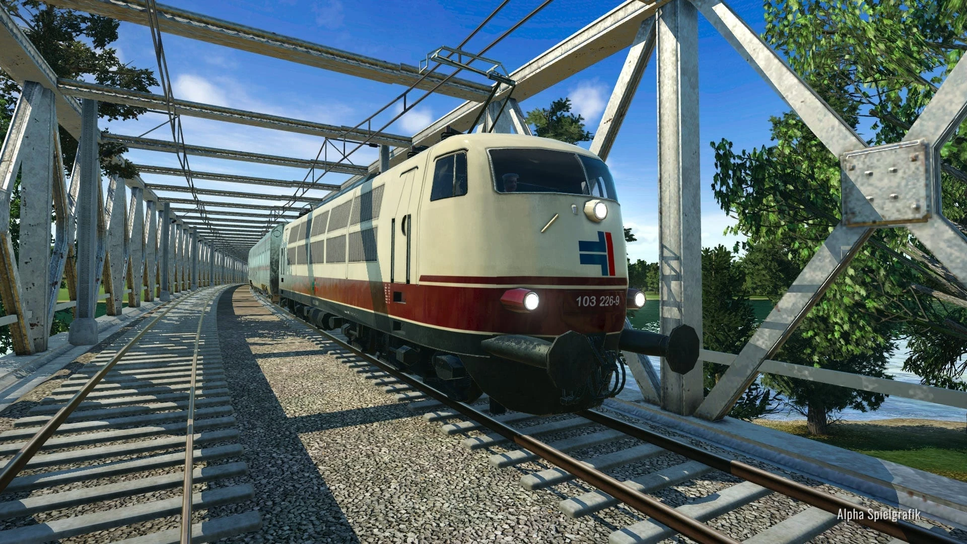 Un tren eléctrico crema y rojo cruza un puente de celosía de hierro entre árboles