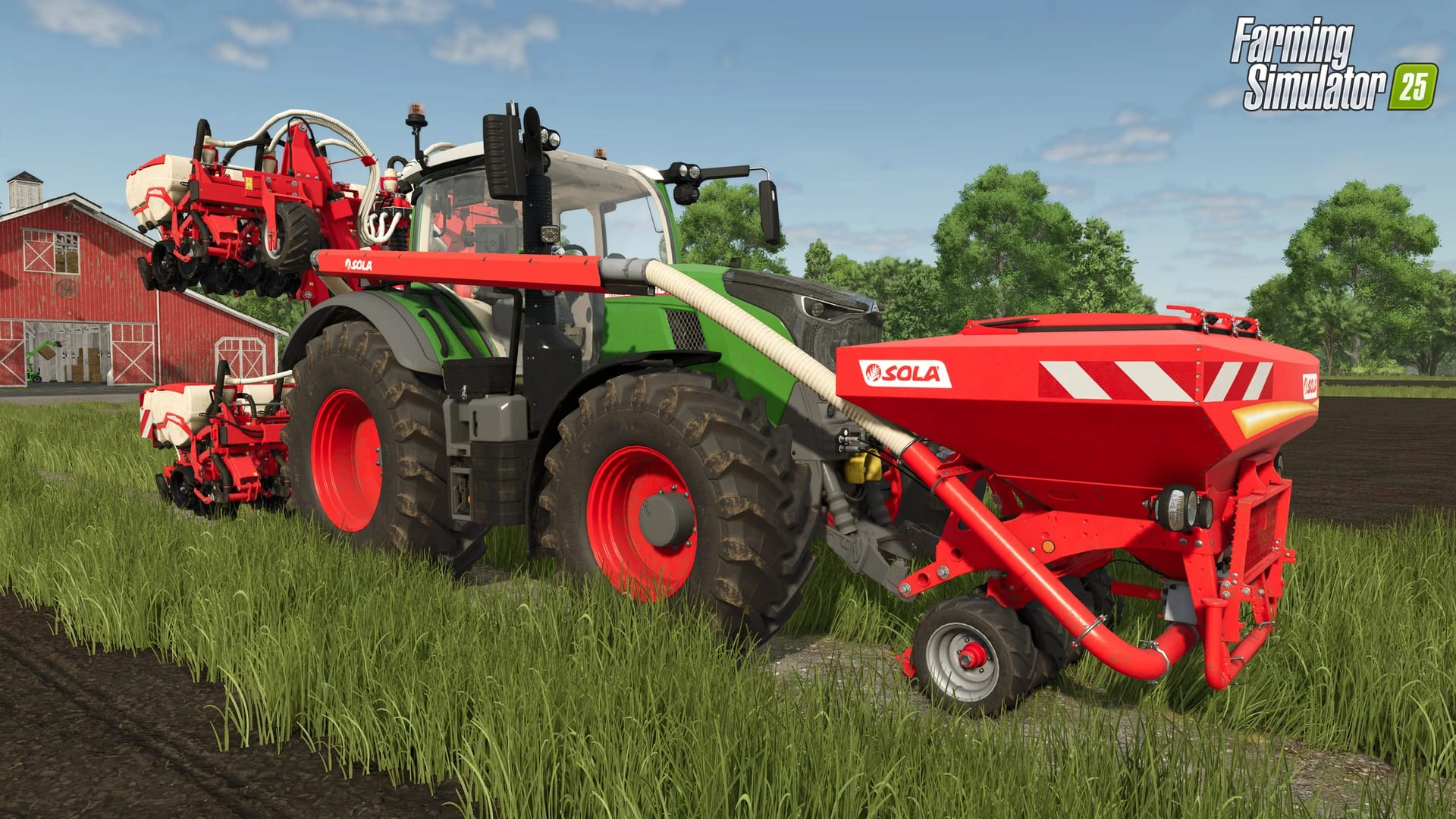 Un tractor verde con una tolva frontal roja de SOLÀ enganchada delante y una sembradora roja plegada detrás, sobre la hierba junto a un granero rojo