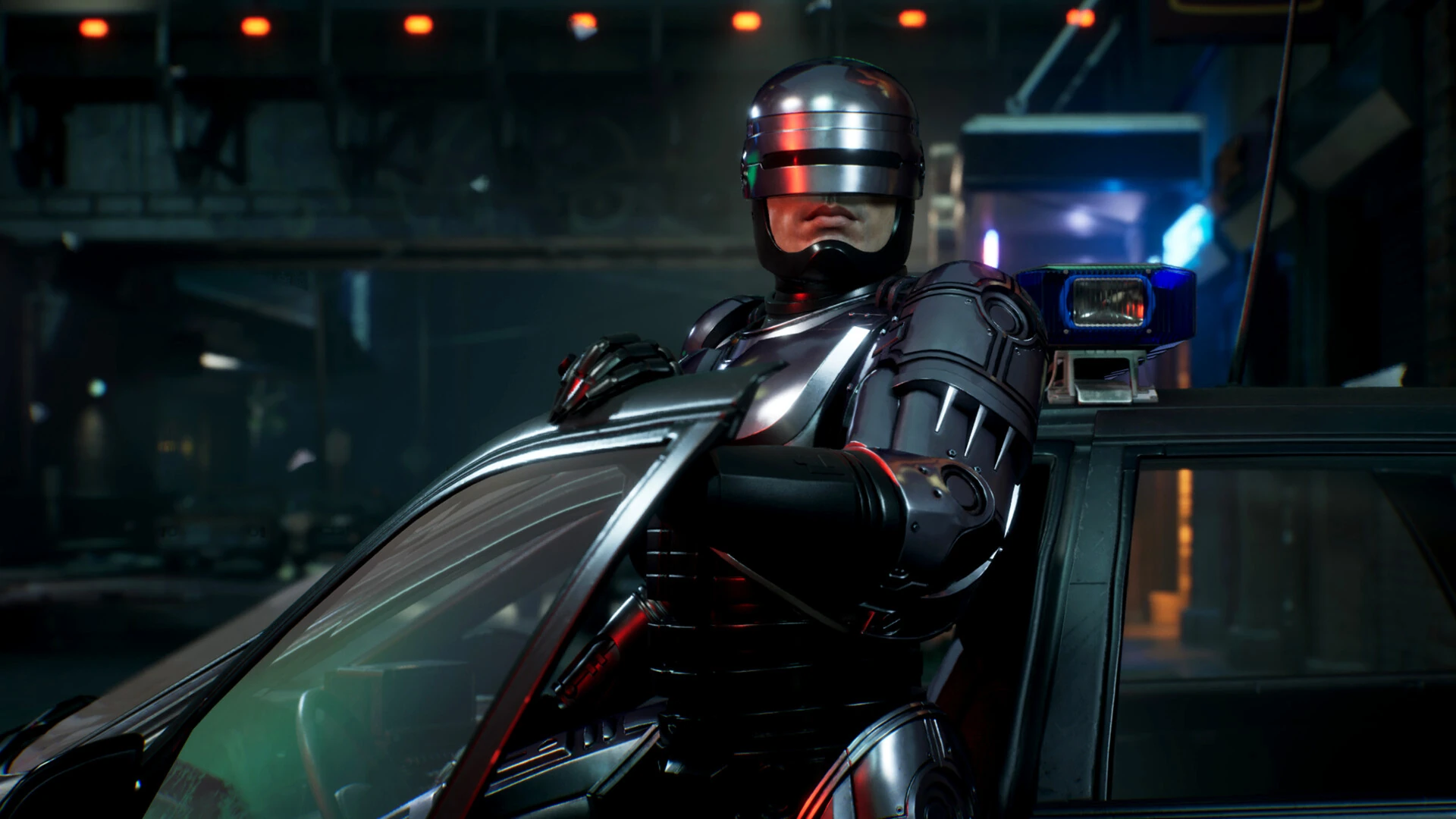 RoboCop, con el casco plateado, apoyado en la puerta abierta de un coche patrulla en una calle de noche