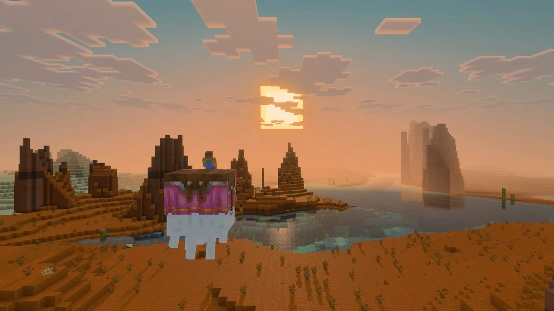 Un jugador de Minecraft montado en un animal con manta rosa contempla la puesta de sol sobre una meseta de tierra roja con agua que refleja el cielo
