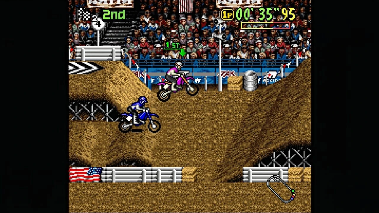 Dos motos de cross saltan montículos de tierra en un estadio con las gradas llenas; marcador de segundo puesto y tiempo de carrera arriba
