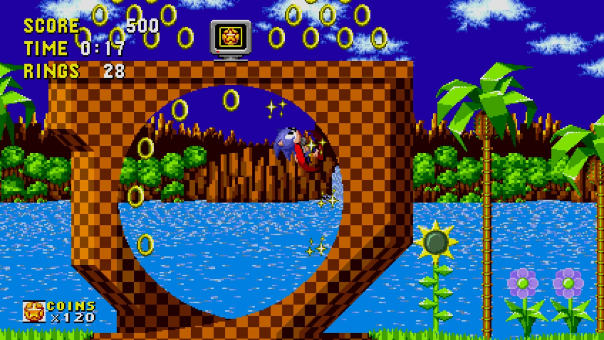 Sonic hecho una bola recorre un rizo a cuadros de Green Hill, rodeado de anillos, con palmeras y un lago al fondo