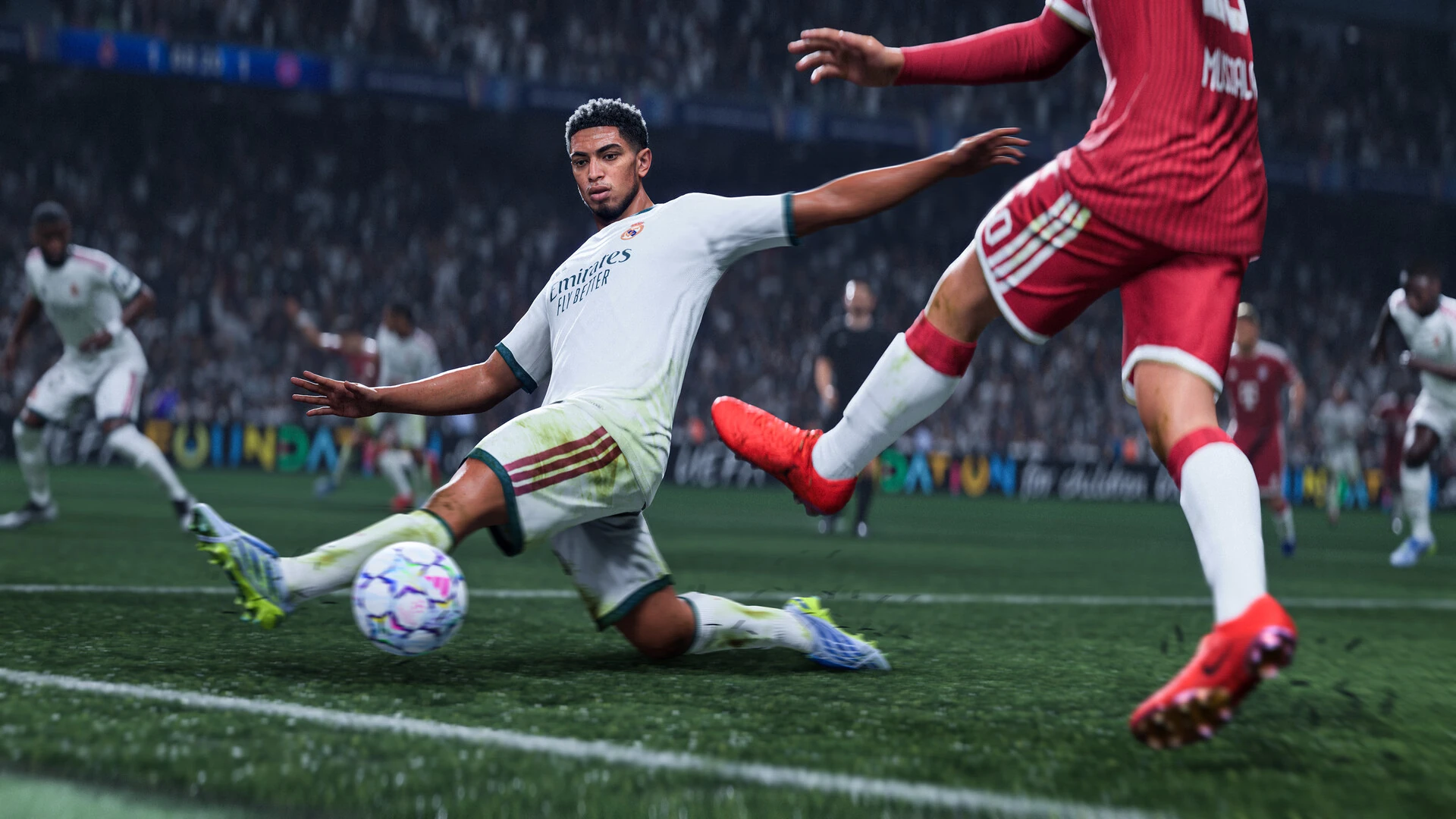 Jude Bellingham, de blanco del Real Madrid, entra al balón deslizándose sobre el césped ante un rival de rojo